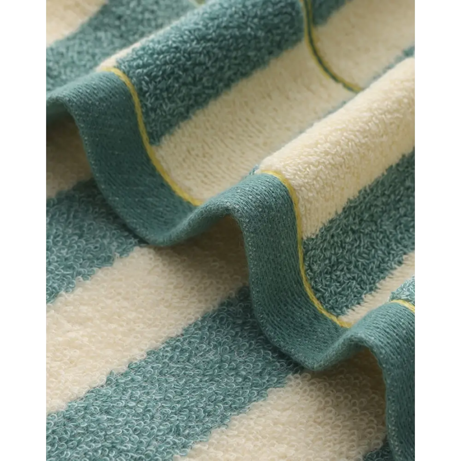 Cotton striped hand towel in gym bag, demonstrating compact travel size