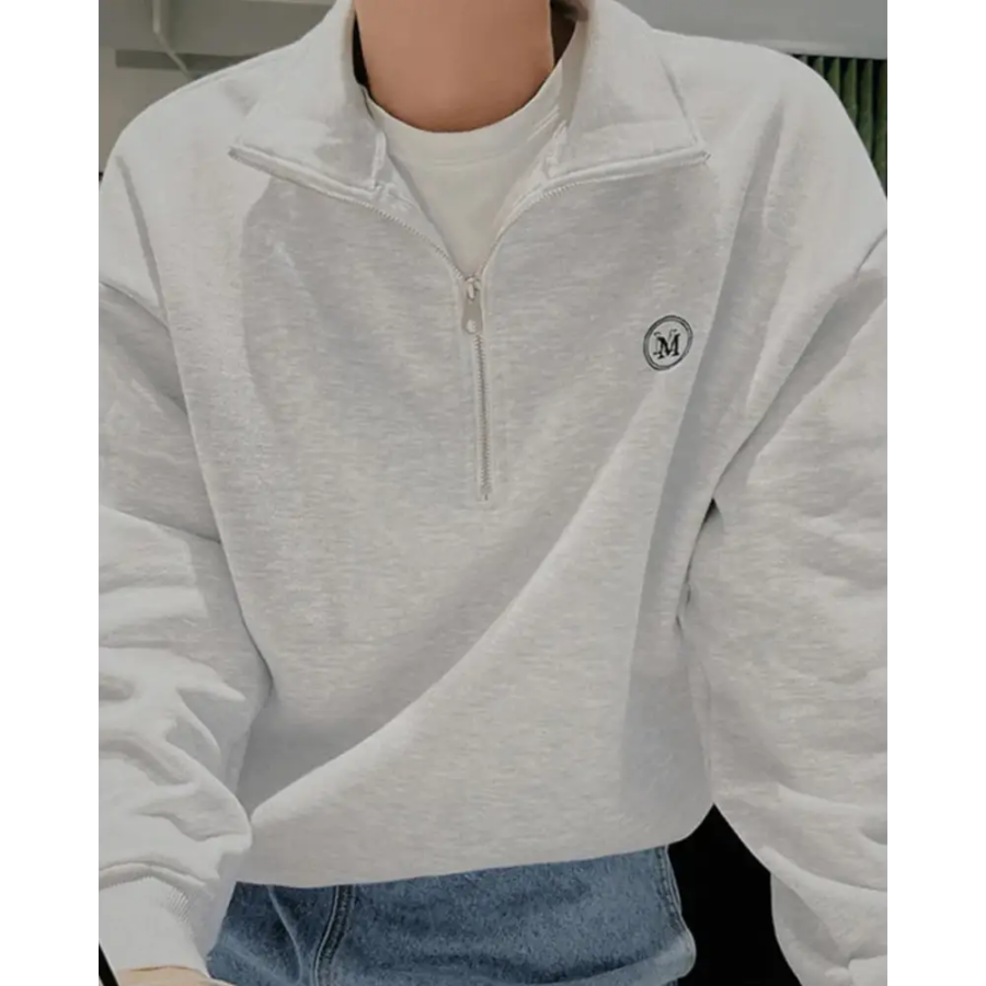 Half-zip neckline detail showing functional zipper and ribbed trim