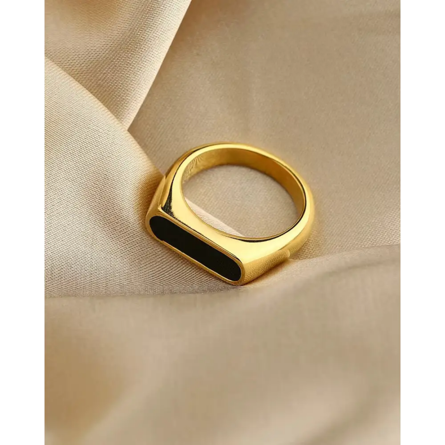 Size 5 gold signet ring on pale hand, minimal black enamel detail