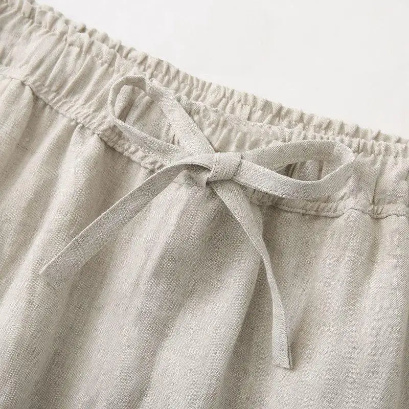 Beige linen drawstring trousers full length view, natural wrinkled texture