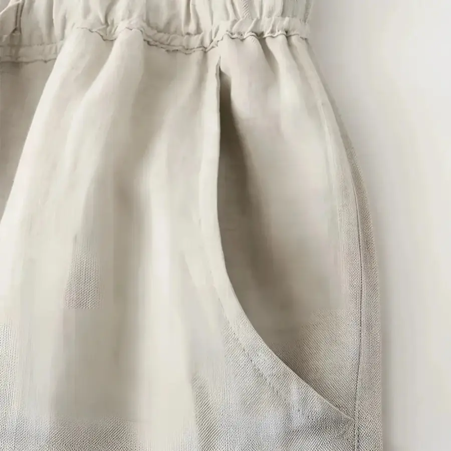 Linen drawstring trousers paired with white shirt, styled for warm-weather wear