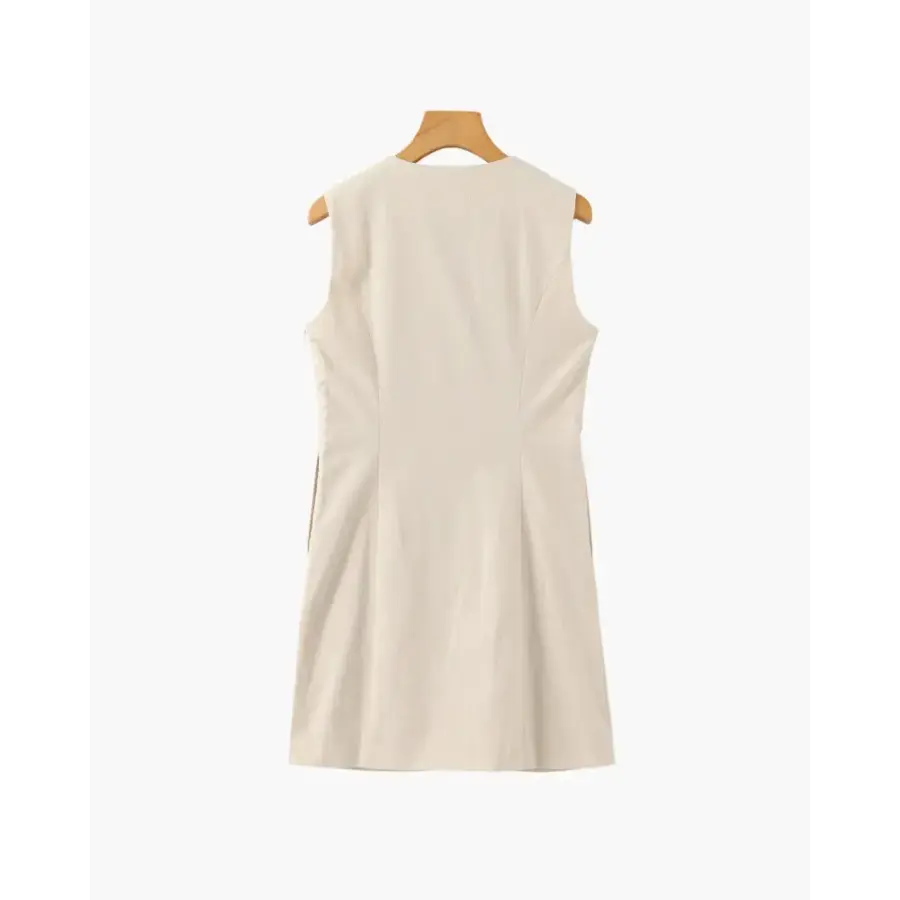 Close-up of wavy button placket and tonal shell-inspired buttons on beige dress