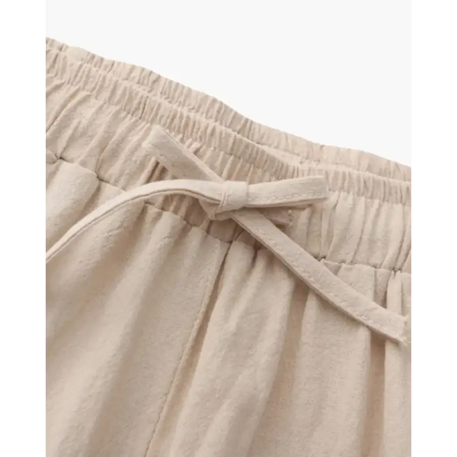 Men's signature linen pants in neutral beige displayed flat to show tailored straight-leg cut and proportions