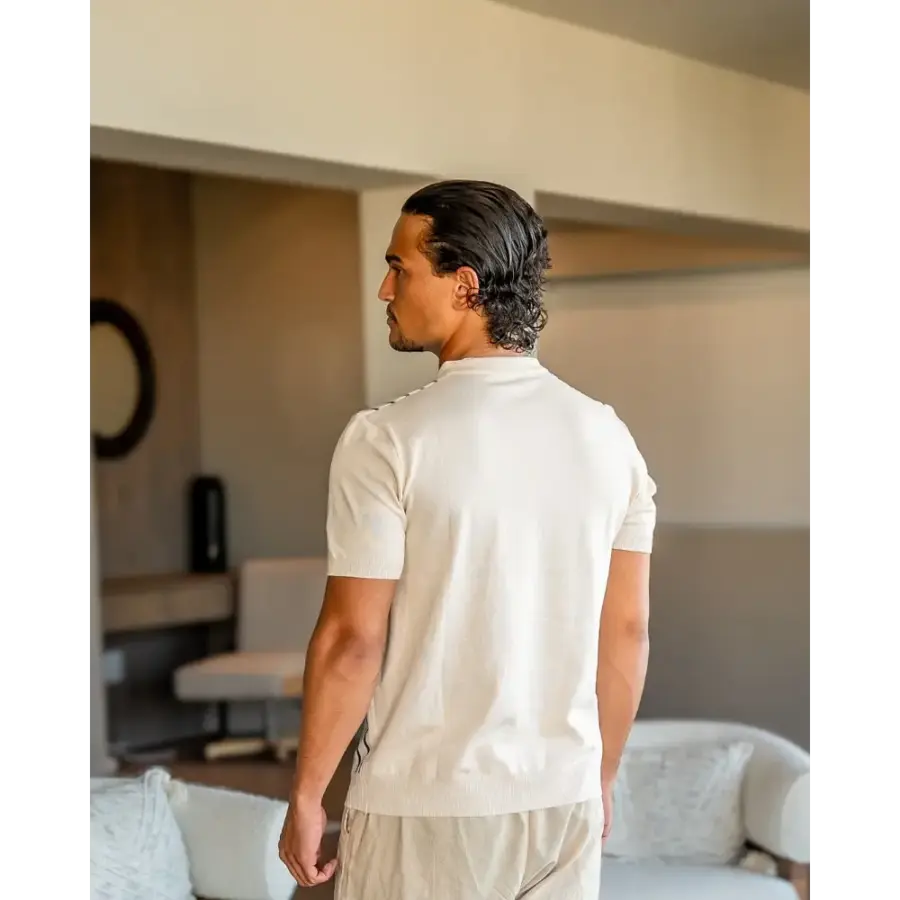 Tailored knit polo shirt worn with tailored trousers, side view