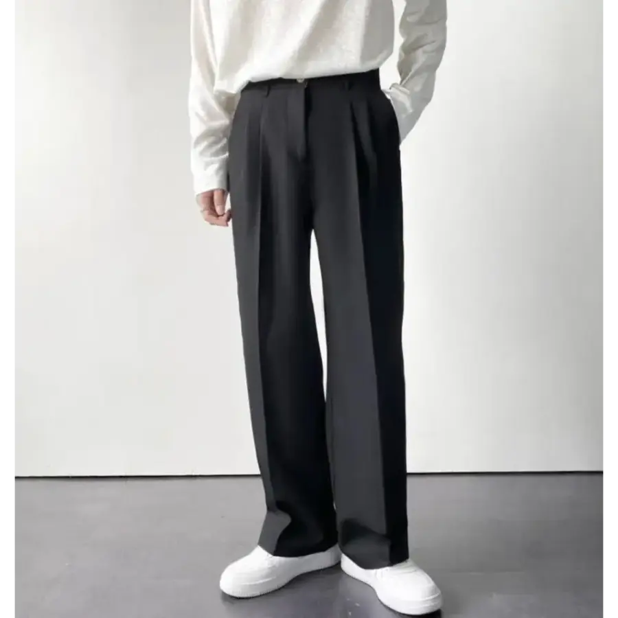 Detail of elastic waistband and fabric drape on relaxed trousers